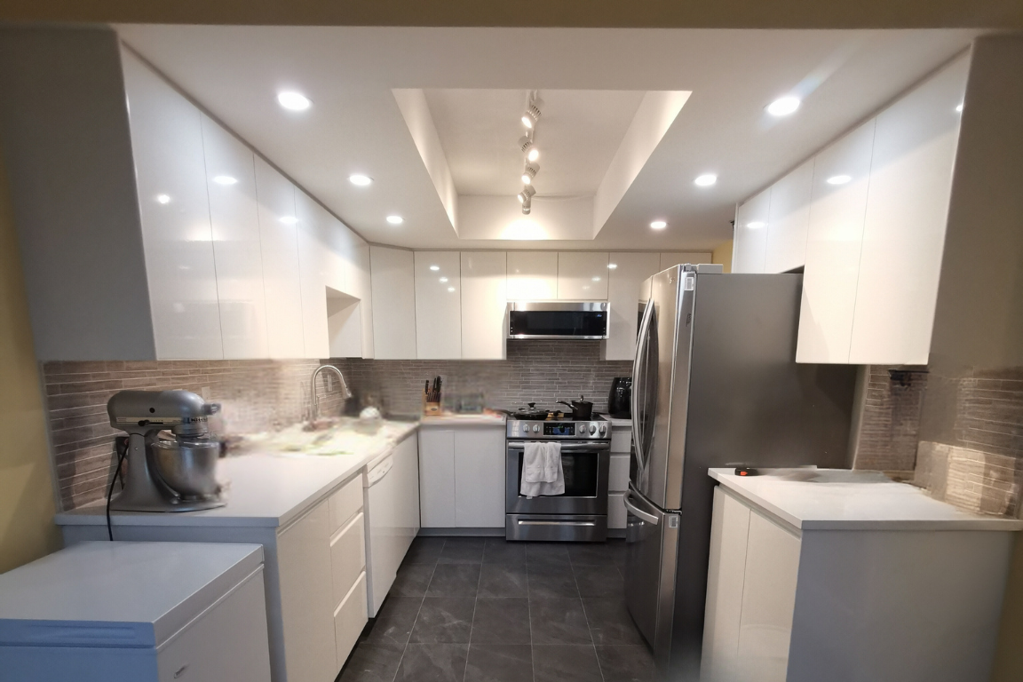 Condo Renovation in Coquitlam: Spacious kitchen with modern design, ample storage, and dark double-door storage under countertop.