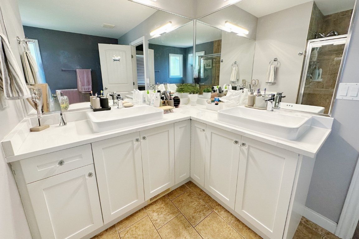 Luxurious bathroom renovation in Langley, BC by Reno Stars, highlighting a corner double vanity with modern sinks and fixtures