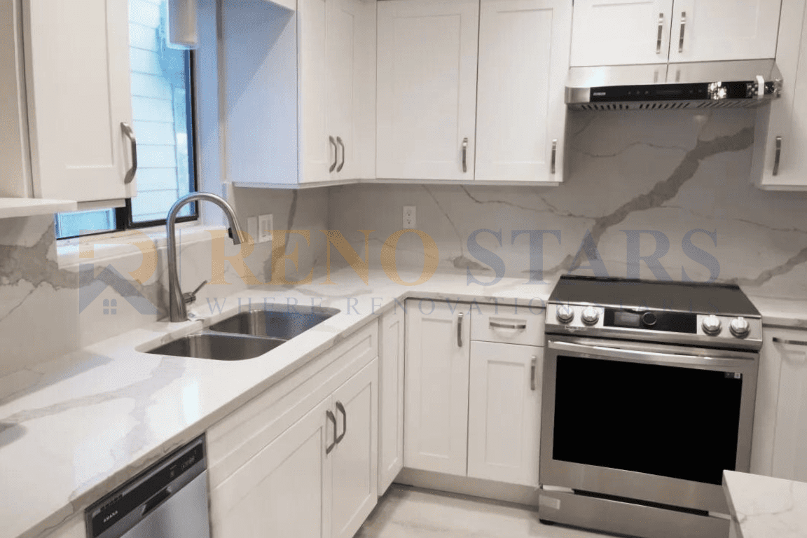 After Home Renovation in Richmond: Sleek kitchen with white cabinetry, marble countertops, and stainless steel appliances.